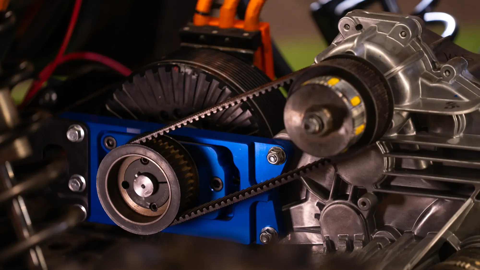 SPM electric drivetrain installed in a vehicle: motor, high-voltage cabling, belt drive and billet mounting plate
